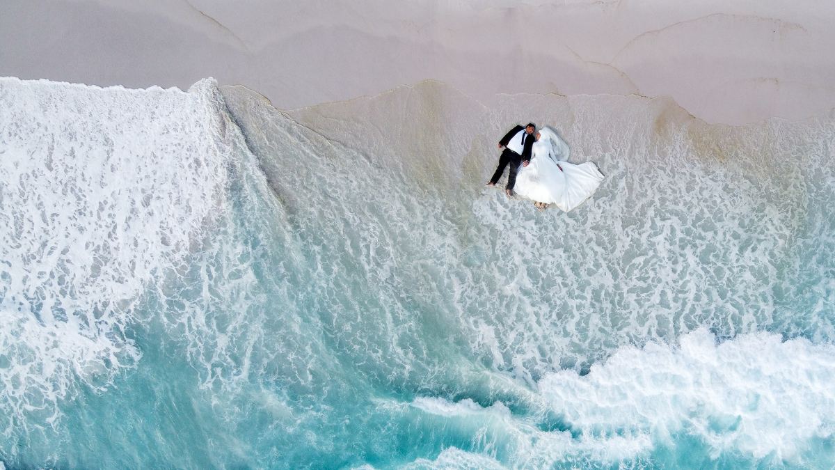 Aerial view of a bridal couple beside the South African coastline