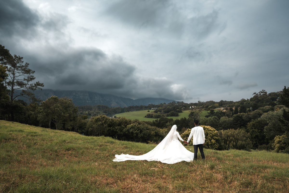 Bride and groom beneath dramatic mountain peaks near Cape Town — landscape wedding photography by My Photo Corner