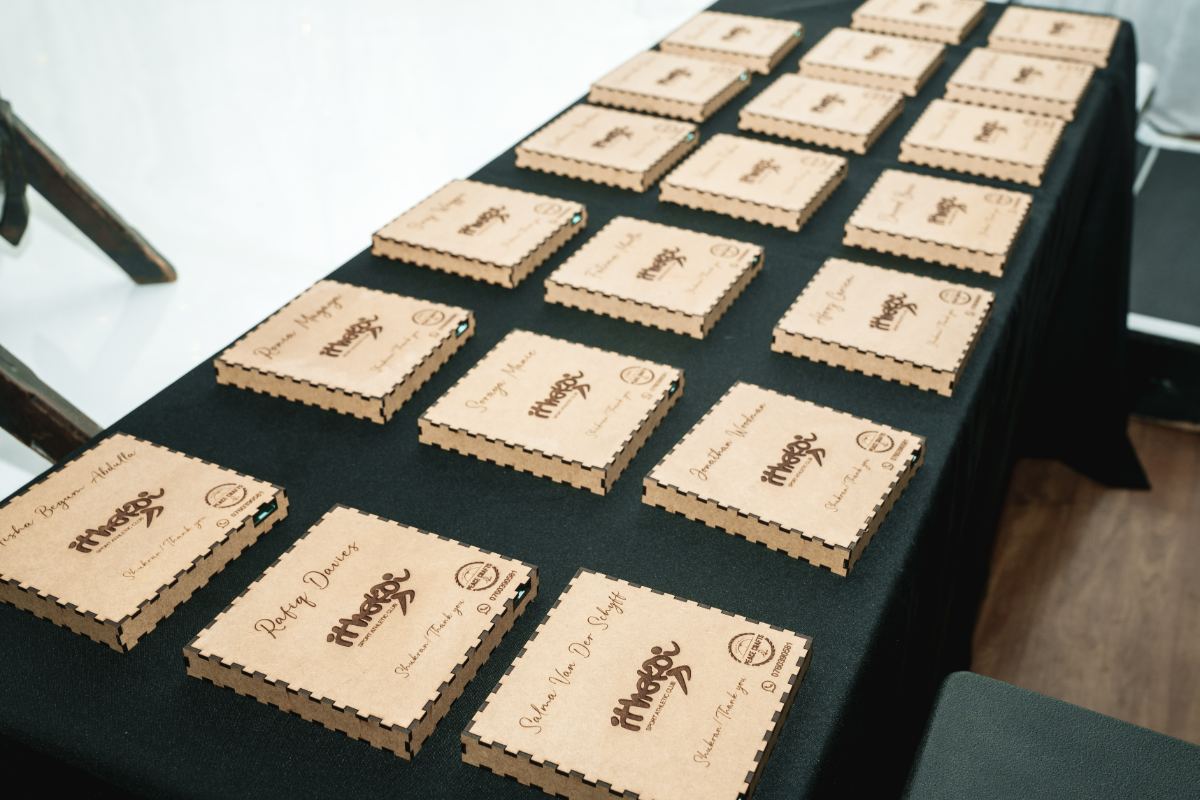 Personalised engraved gift boxes laid out at a corporate event — event detail photography
